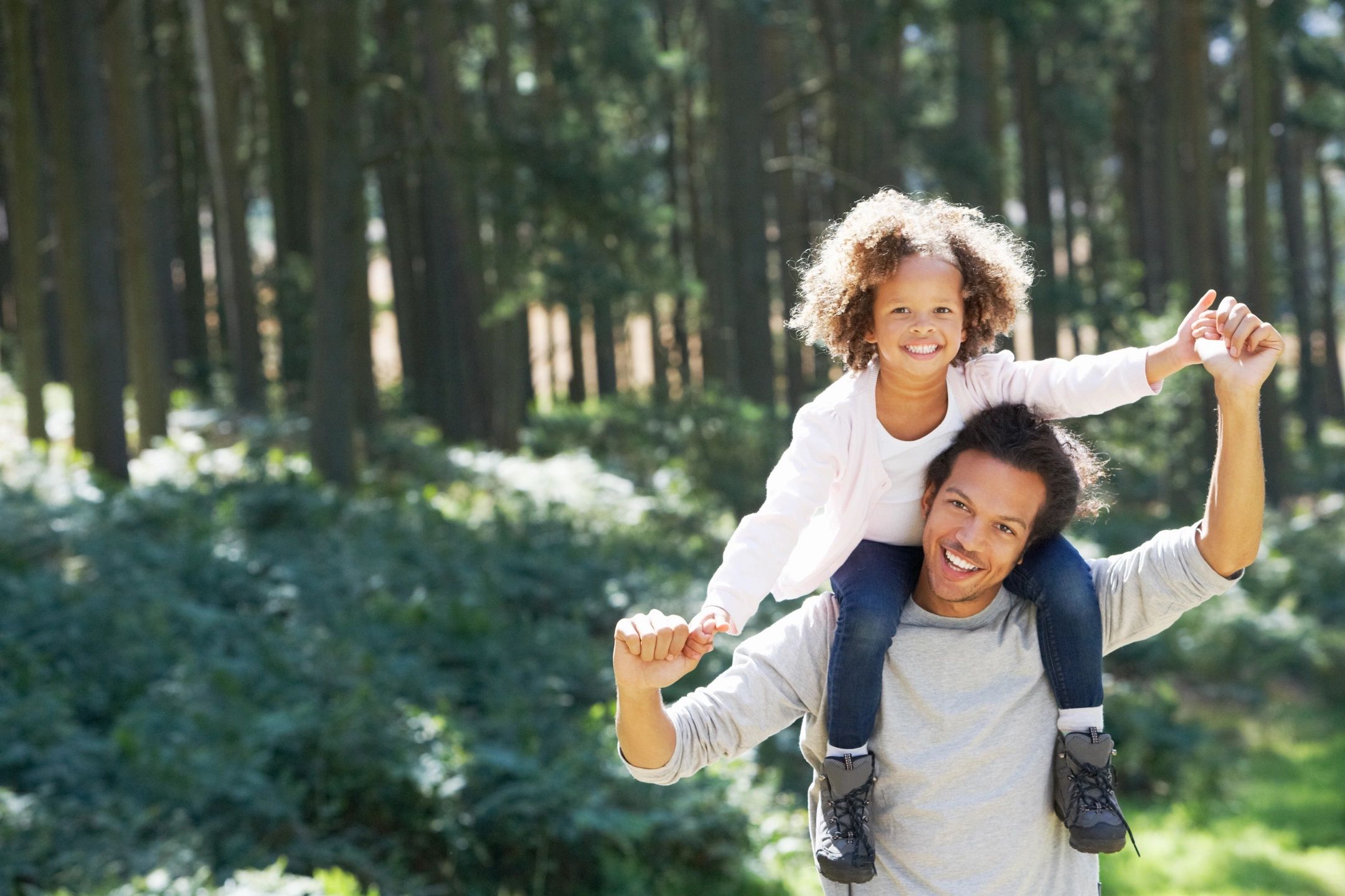 Father carrying young daughter on his shoulders